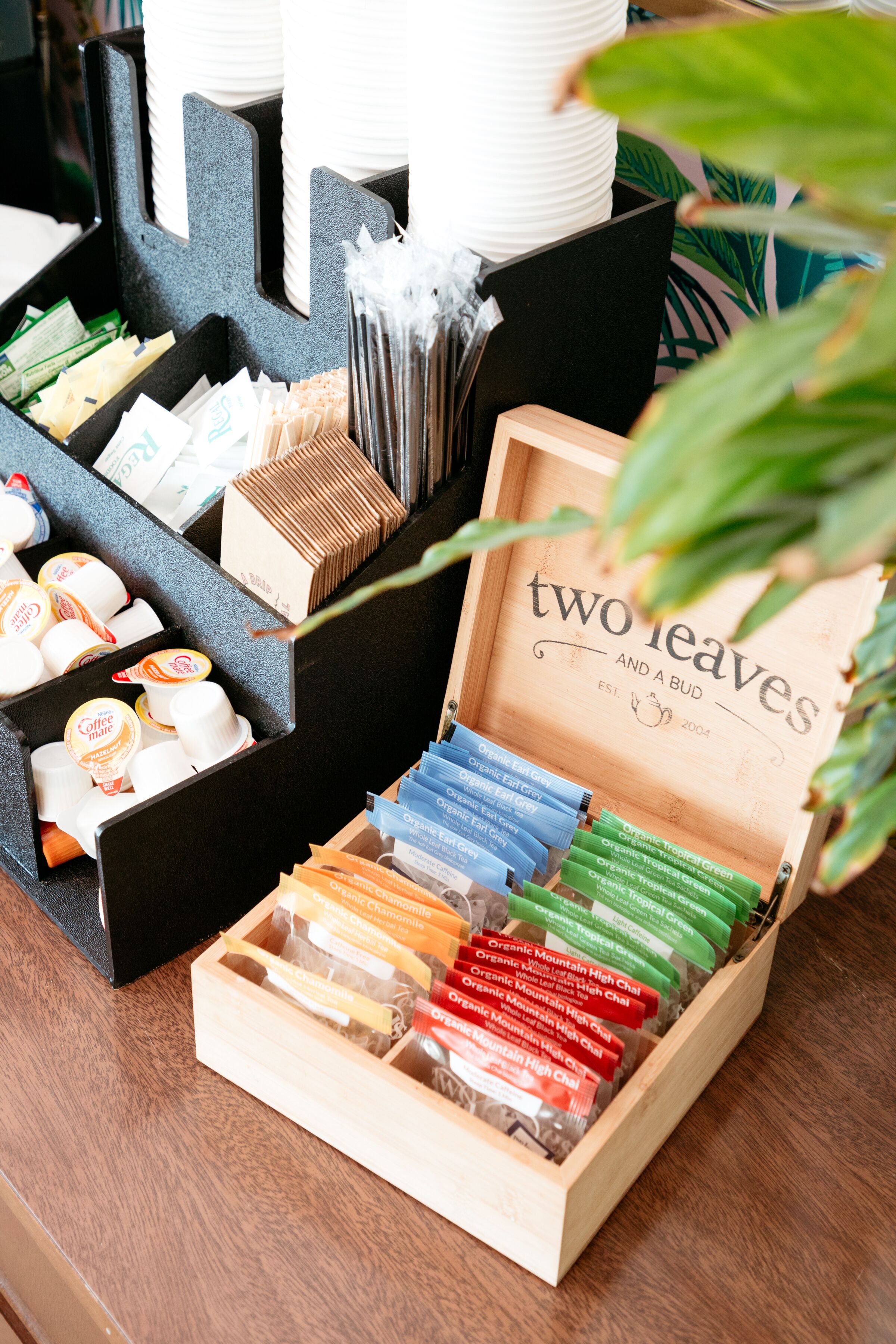 A wooden box labeled "two leaves" containing various organic teas.