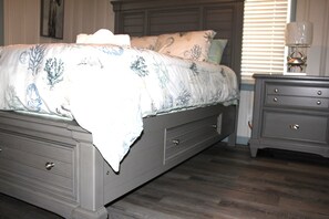 Restful retreat with a large bed, dresser, and nightstand.