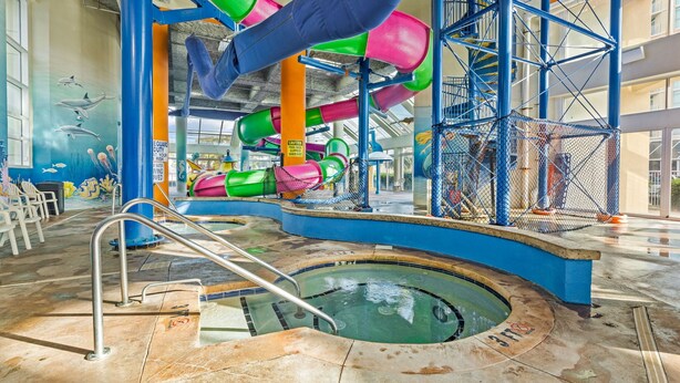 Un parc aquatique intérieur doté de toboggans, d’une piscine et d’une fresque représentant la vie marine.