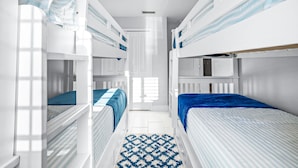 A compact, well-lit room with bunk beds, a small window, and a patterned rug. - Beachside Escape Magnolia Townhome w/Game Room, Fire pit, BBQ grills & Private Balcony! (Cape Canaveral)