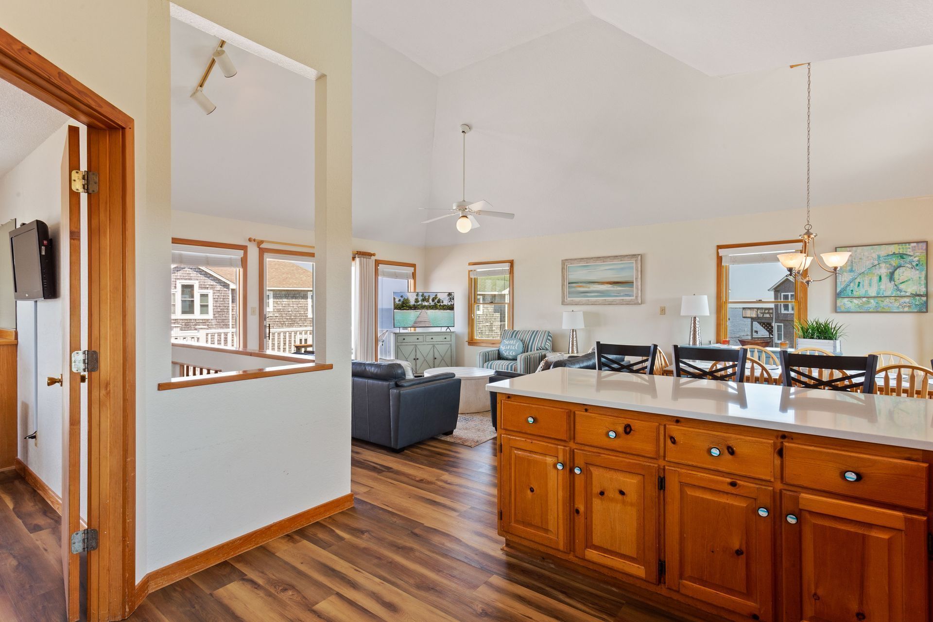 A spacious kitchen with wooden cabinets, a dining area with a large island, and a view of the outside.