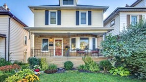 A two-story house with a front porch, a small garden, and a mailbox. - The Hipster House  (Windsor)