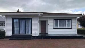 Une maison de plain-pied avec une porte d’entrée, une grande fenêtre et un petit porche.