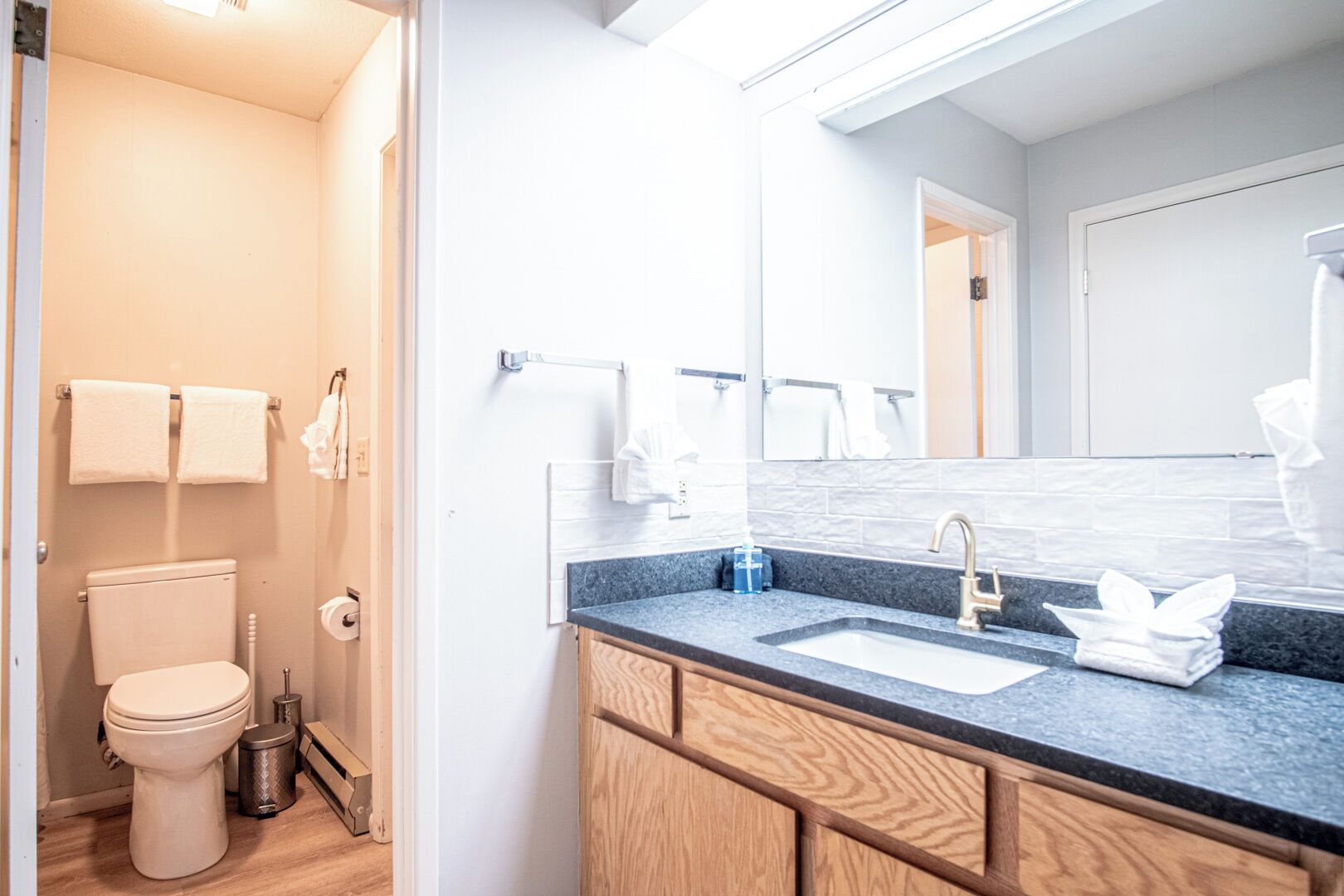 Ein modernes Badezimmer mit Toilette, Waschbecken und Spiegel.