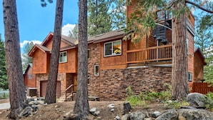 A two-story log cabin with a stone foundation, large windows, and a wooden balcony. - Lake Views and Mountain Luxury Lx66 (Zephyr Cove)