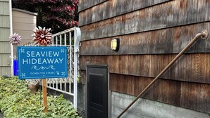 A blue sign for 'Seaview Hideaway' with a directional arrow pointing down the stairs. - Seaview Hideaway 2BR Near Alki Beach & Stadiums (Seattle)