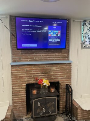 Living Room with wood burning fireplace and Roku TV