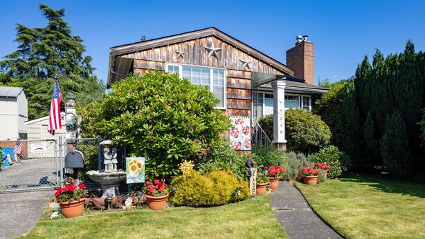 A rustic building with a wooden facade, a brick chimney, and a welcoming sign. - Seaview Hideaway 2BR Near Alki Beach & Stadiums (Seattle)