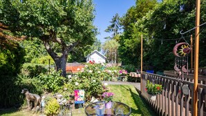 A garden with a glass table, a wooden fence, and a house in the background. - Seaview Hideaway 2BR Near Alki Beach & Stadiums (Seattle)