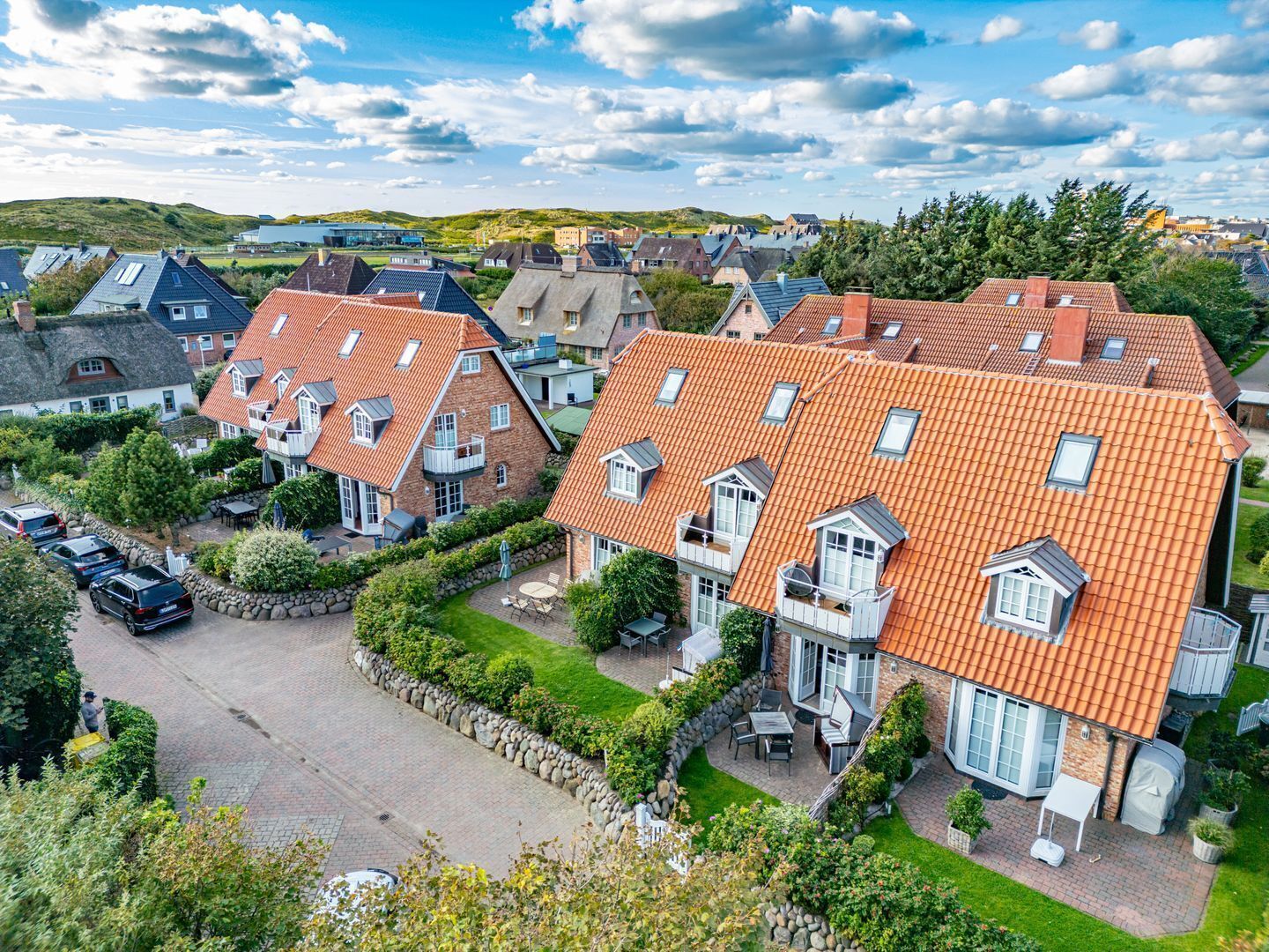 A residential area with houses featuring red-tiled roofs and stone facades.