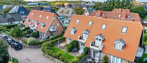A residential area with houses featuring red-tiled roofs and stone facades.