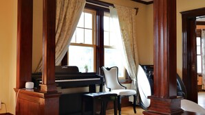 A piano in a room with wooden trim and large windows. - Beautiful Victorian home, Great view with balcony. Free parking. (Boston)