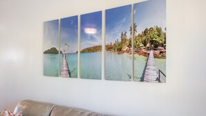 A four-panel artwork depicting a tropical beach scene with a pier and palm trees. - Wonderful Honokowai Beach Condos (Lahaina)