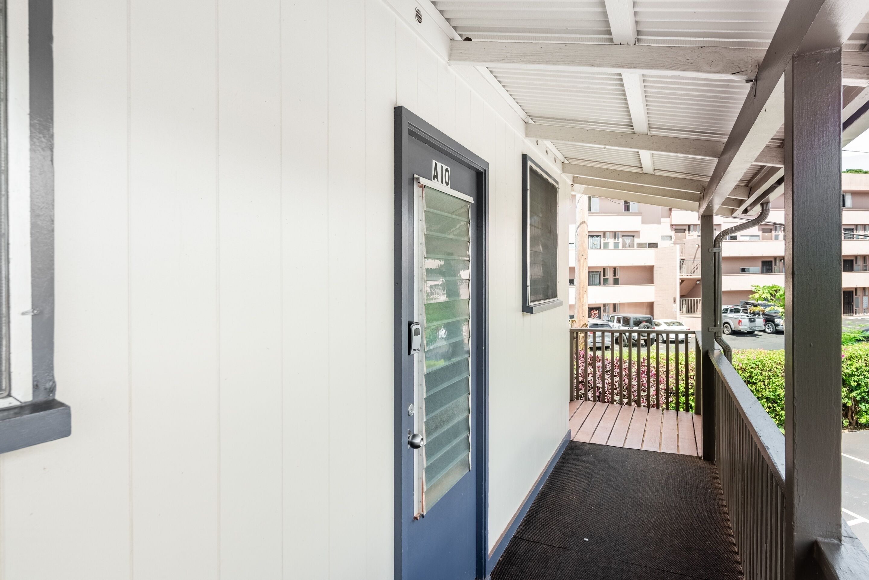 A corridor with a blue door labeled "A10" leading to a balcony.