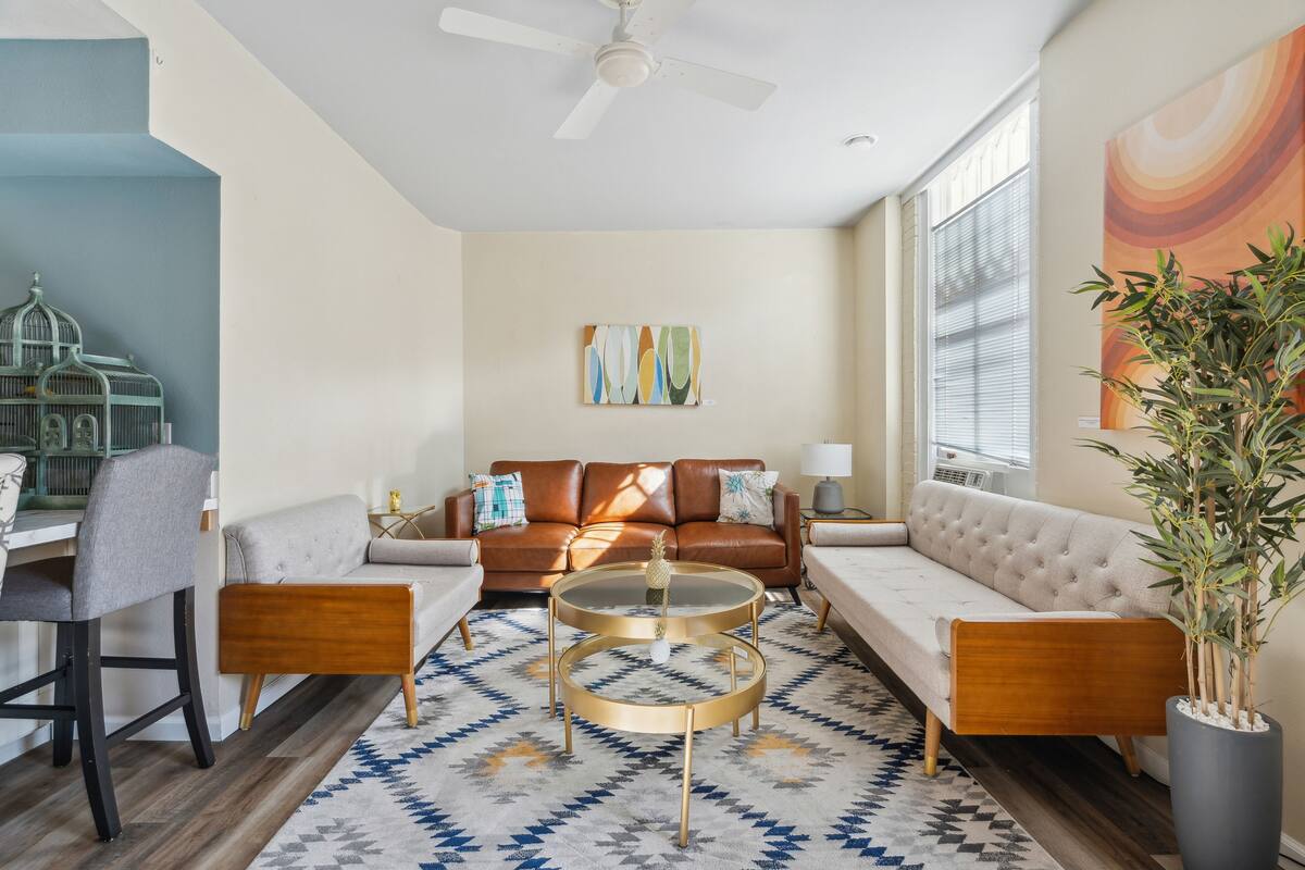A living room with a sofa, coffee table, and a potted plant.
