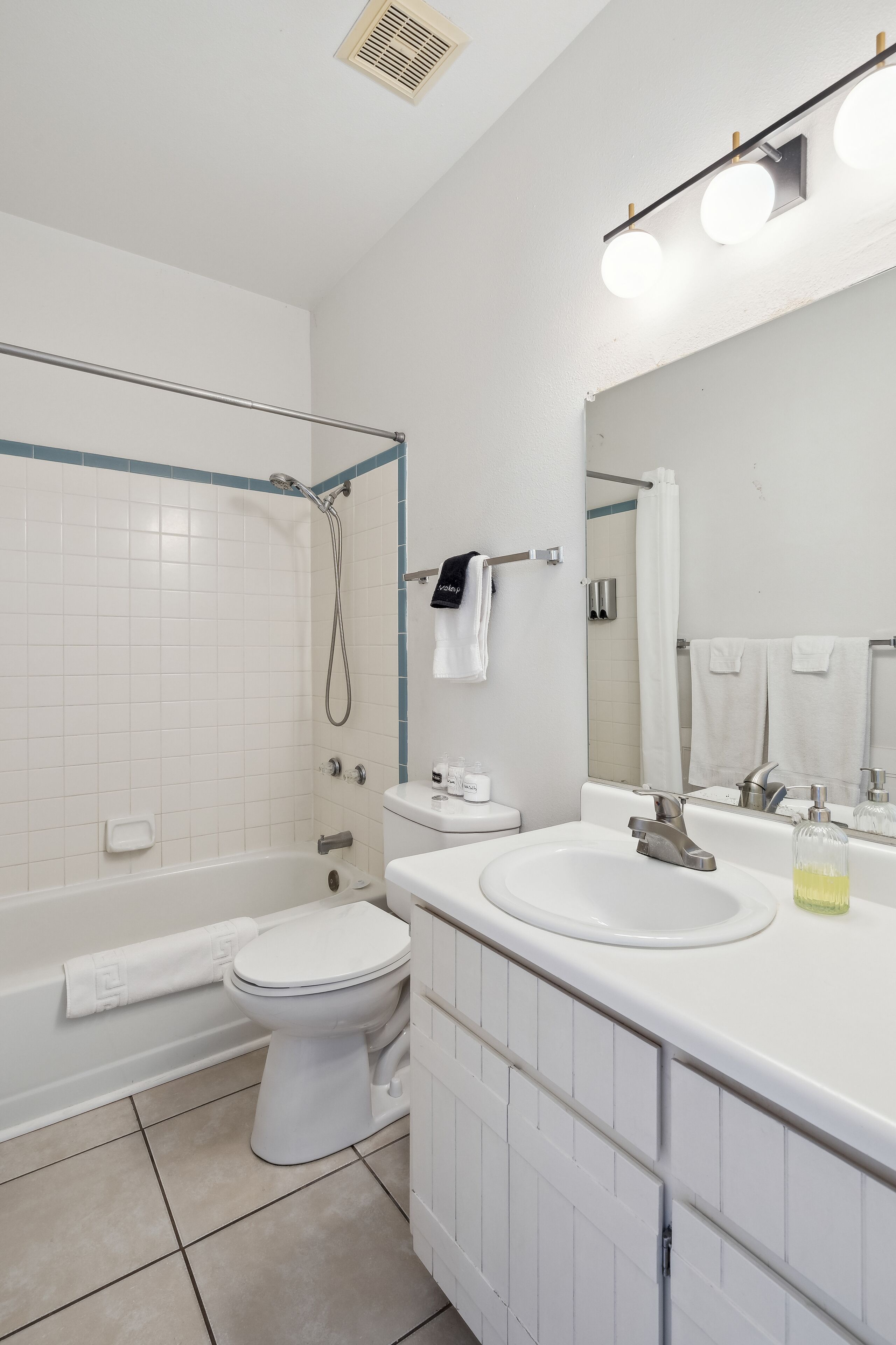 A modern bathroom with a bathtub, toilet, and sink.