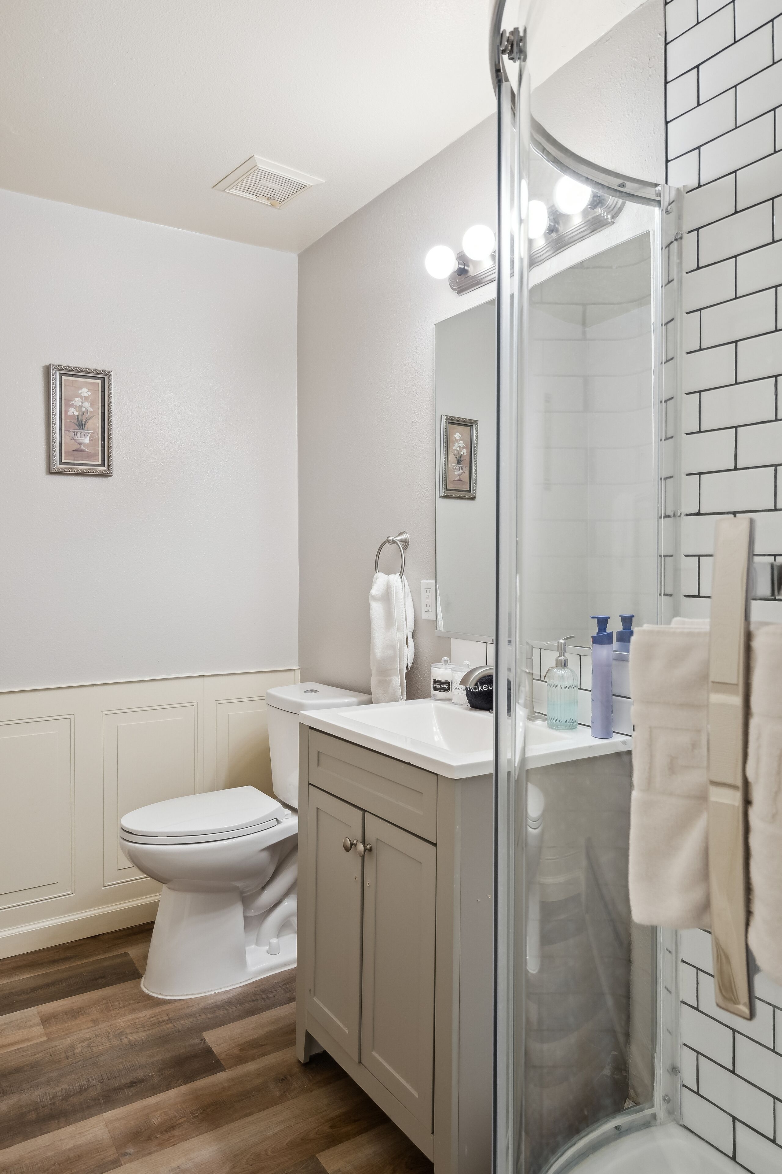 Une salle de bain comprenant des toilettes, un lavabo et un espace douche.