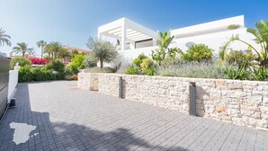 Un edificio moderno con un muro de piedra y un camino de entrada pavimentado.