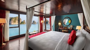 A spacious room with a large bed, a view of the sea, and a wooden ceiling. - Indochine Premium Halong Bay (Tuan Chau)