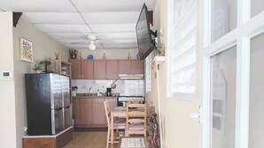 Cocina compacta con refrigerador, estufa y zona de comedor.