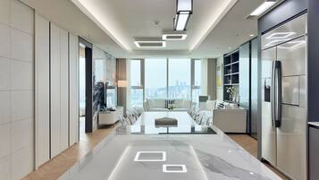 A modern kitchen with a marble countertop, built-in appliances, and a city view.
