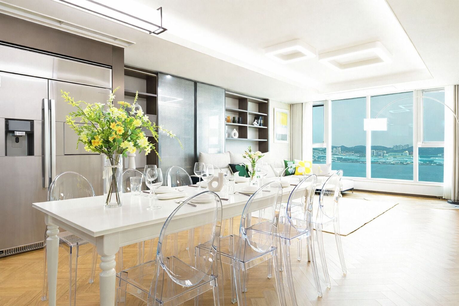 A modern kitchen with a dining area, large windows, and a view of the city.