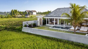 A modern house with a pool, a garden, and a view of the surrounding fields. - Villa Grateful by Alfred in Bali (Sukawati)