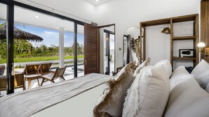 A modern room with a large window, a hammock, a sofa, and a wooden shelf. - Villa Grateful by Alfred in Bali (Sukawati)