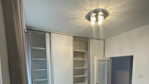 A room with a ceiling light fixture, a sliding closet door, and a door. - 4-Bedroom House Sleeps 7 with Garden (Senec)