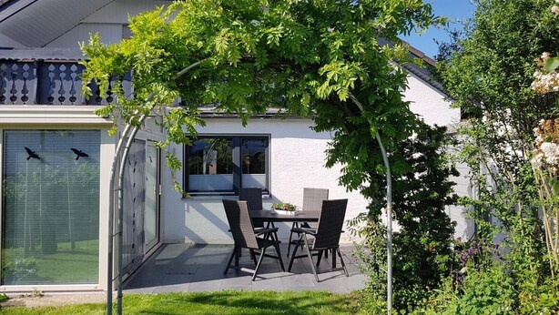 A modern house with a patio, a dining table, and chairs. - Vacation apartment Dahlie, 60 sqm, 1 bedroom, max. 3 persons (Münsingen)