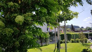 A well-maintained garden with a wooden play structure, a metal fence, and a grassy area. - Vacation apartment Dahlie, 60 sqm, 1 bedroom, max. 3 persons (Münsingen)