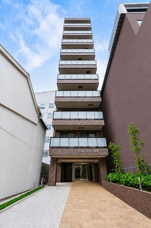 A modern building with a nameplate reading 'Sincere Bld.' It features a multi-story structure with a series of balconies and a glass facade. - Hotel Piacere Namba (Osaka)