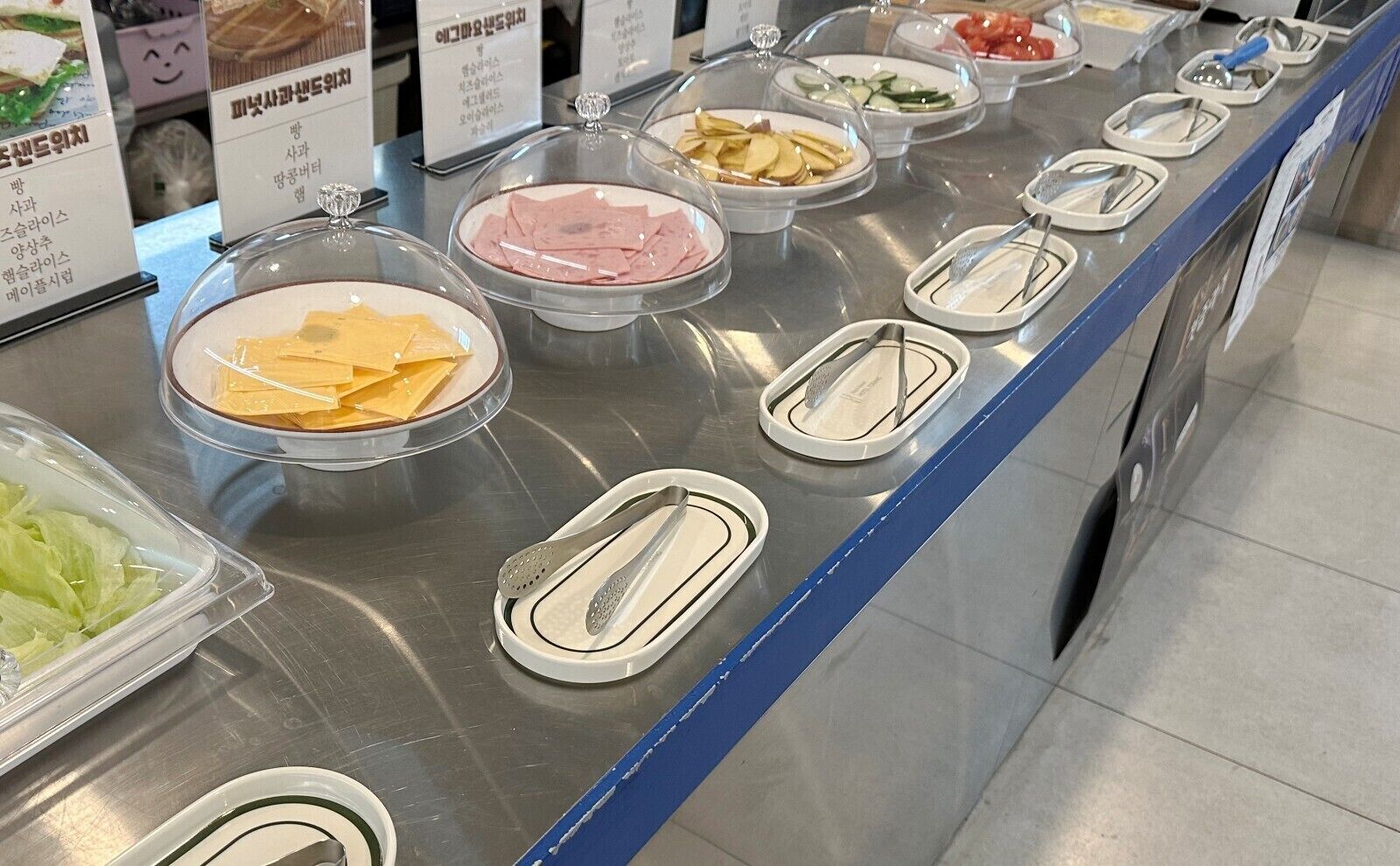 Una barra de buffet con diversos alimentos y utensilios.