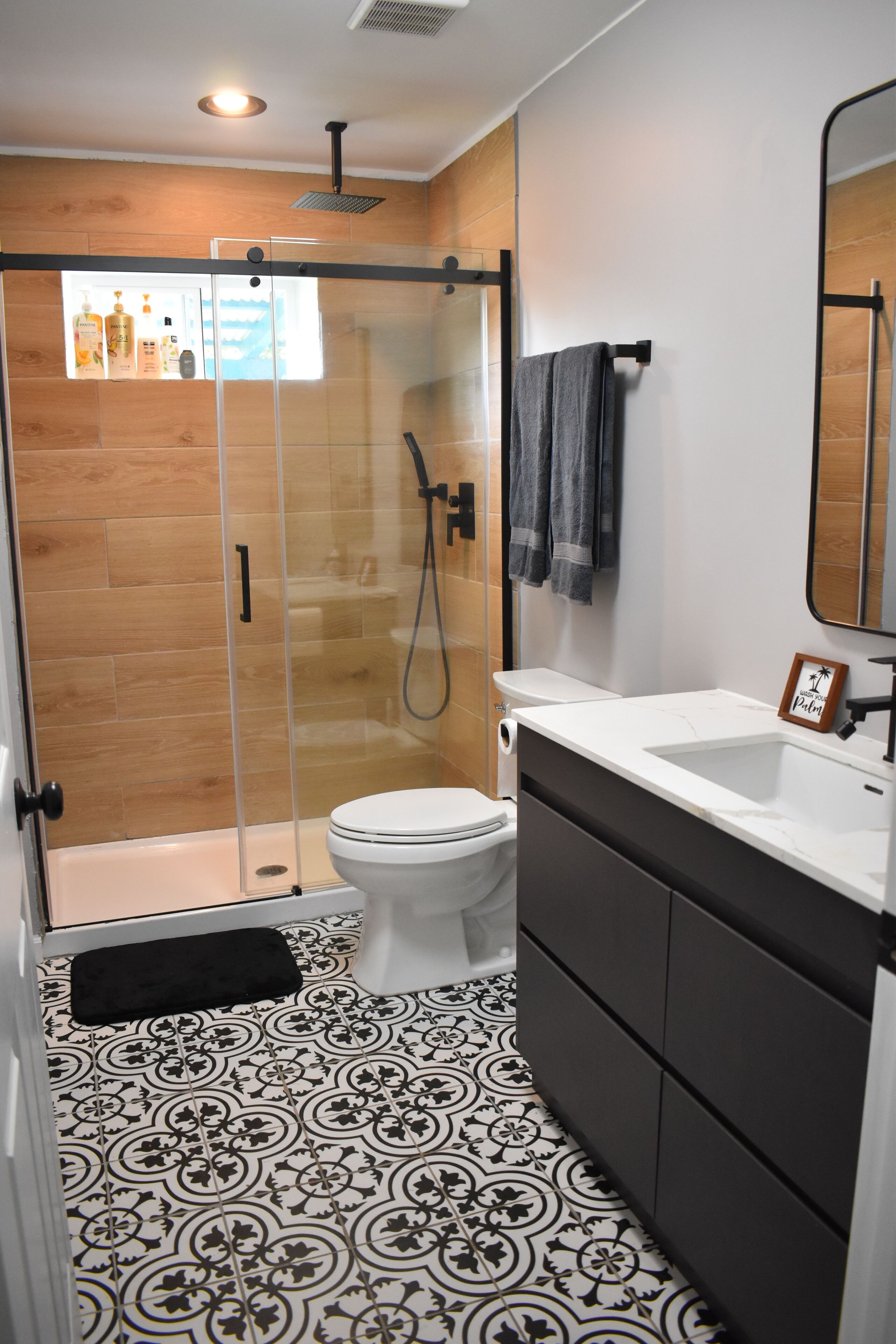 Un bagno moderno con box doccia in vetro, un water, un lavabo e un mobile lavabo.