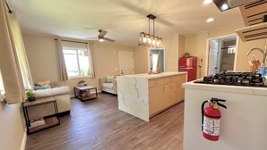 A spacious living area with a sofa, a coffee table, and a dining area with a kitchen counter.
