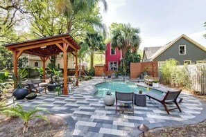 A backyard with a swimming pool, patio furniture, and a wooden pergola. - Unique Oasis in the Heart of Springfield! (Jacksonville)