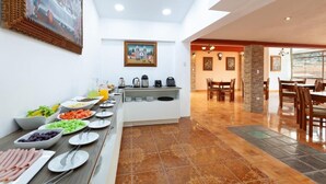 Una mesa de buffet con diversos alimentos y una estación de café.