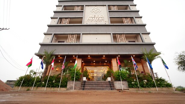 A multi-story hotel with a modern design, featuring a prominent logo and name at the entrance. - Mevid hotels (Hyderabad)