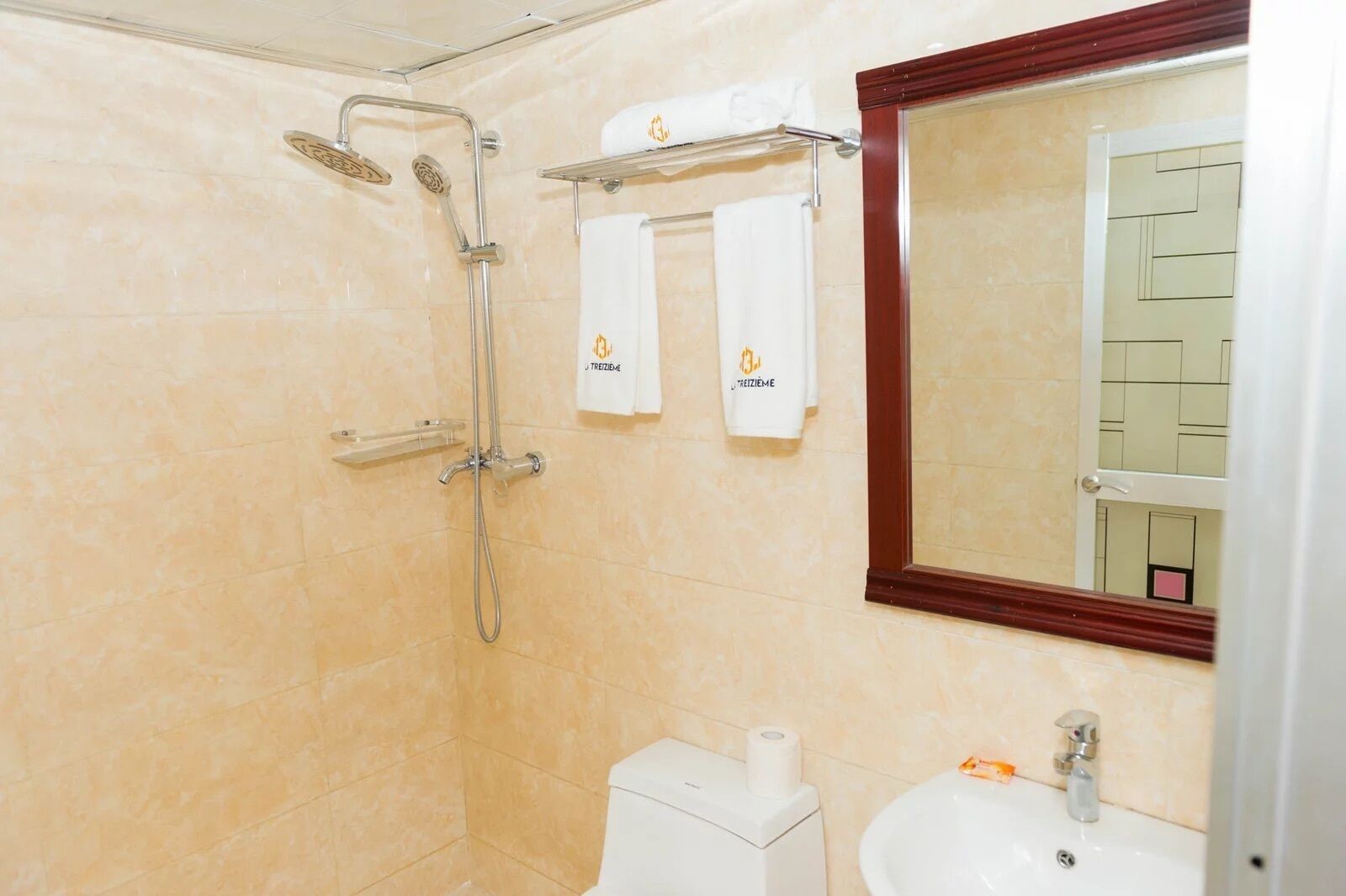 A bathroom with a shower, toilet, sink, and towels.