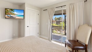 A bedroom with a bed, a chair, a TV, and a sliding glass door to a balcony. - Caloosahatchee Hideaway I, Waterfront Farmhouse Escape, Near Babcock Ranch (Fort Myers)