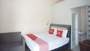 Ein Schlafzimmer mit Bett, einer Sitzecke und einem Badezimmer.