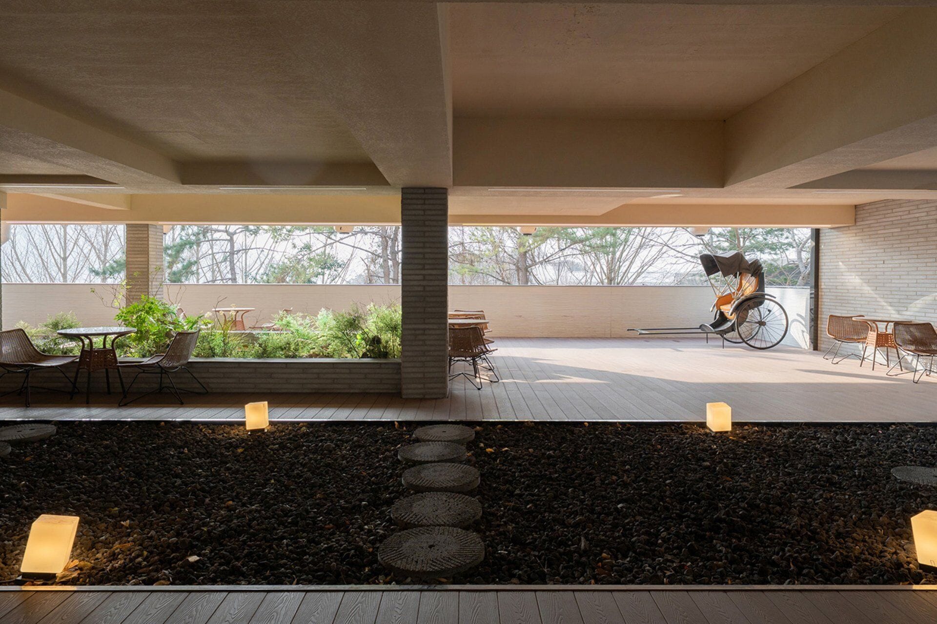 An outdoor patio area with a wheelchair, seating, and a garden view.
