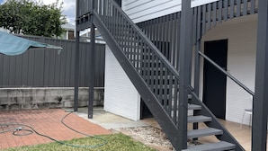 A two-story house with a grey staircase leading to a covered porch. - Cosy and private self contained retreat in a great location, pet friendly (Graceville)