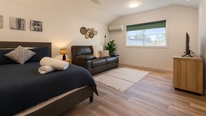 A bedroom with a bed, a sofa, a desk, and a ceiling fan. - Cosy and private self contained retreat in a great location, pet friendly (Graceville)