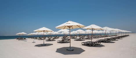 Privatstrand, weißer Sandstrand, Liegestühle, Sonnenschirme