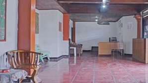 Quarto amplo com piso ladrilhado, mobiliário de madeira e uma escrivaninha.