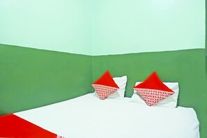 A bed with white bedding and red pillows, set against a green and white wall. - OYO 92994 Wisma Kencana Indah (Karehkel)