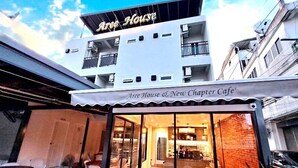 A cafe with a modern exterior, large windows, and outdoor seating. - Aree House Poshtel (Pattaya)