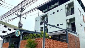 A building with a sign reading "Tree House" and a cafe named "House of New Chapter Cafe" with outdoor seating. - Aree House Poshtel (Pattaya)