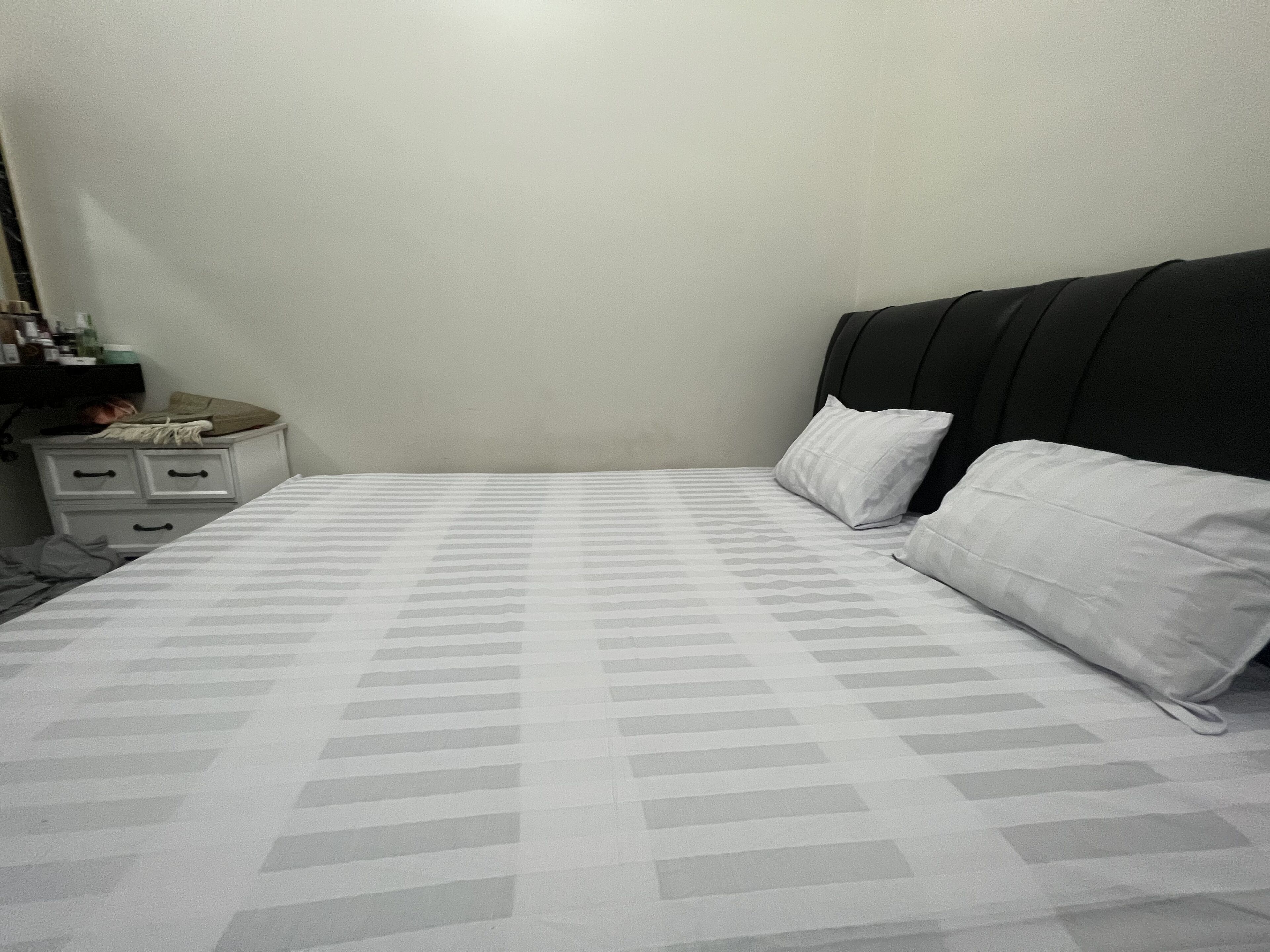 Ein Schlafzimmer mit einem Bett, einem Nachttisch und einer Kommode.